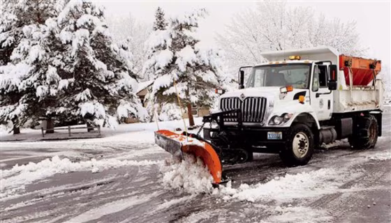 A snow plow clears neighborhood roads in Carson City, Nev., on Friday.